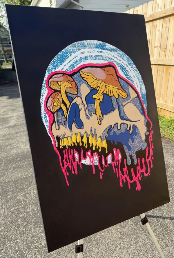 Angled view of the Drippy Mushroom Skull acrylic painting on canvas, showing depth, texture, and glowing details. The skull drips with neon pink paint while yellow mushrooms rise from the top, set against a cosmic blue and white dotted background. Unique 1 of 1 original, signed and labeled on the back.