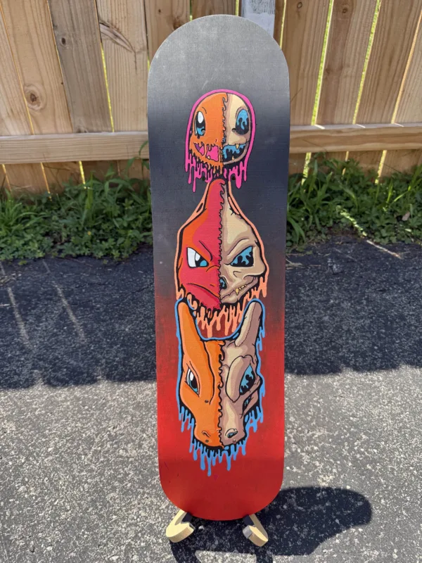 Original acrylic skateboard deck featuring drippy skull designs of Charmander, Charmeleon, and Charizard stacked vertically. Painted in fiery neon colors with fluorescent blacklight glow, finished in acrylic gloss. One-of-a-kind, signed and labeled on the back. Stand not included.