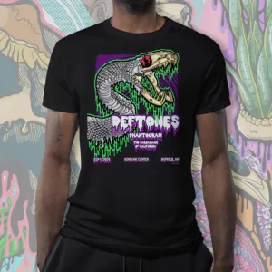 Black unisex t-shirt featuring a serpent skull design with neon green drips and a bold purple background. The artwork includes sharp fangs, coiled snake scales, and dripping gothic-style text inspired by a Deftones Buffalo concert.