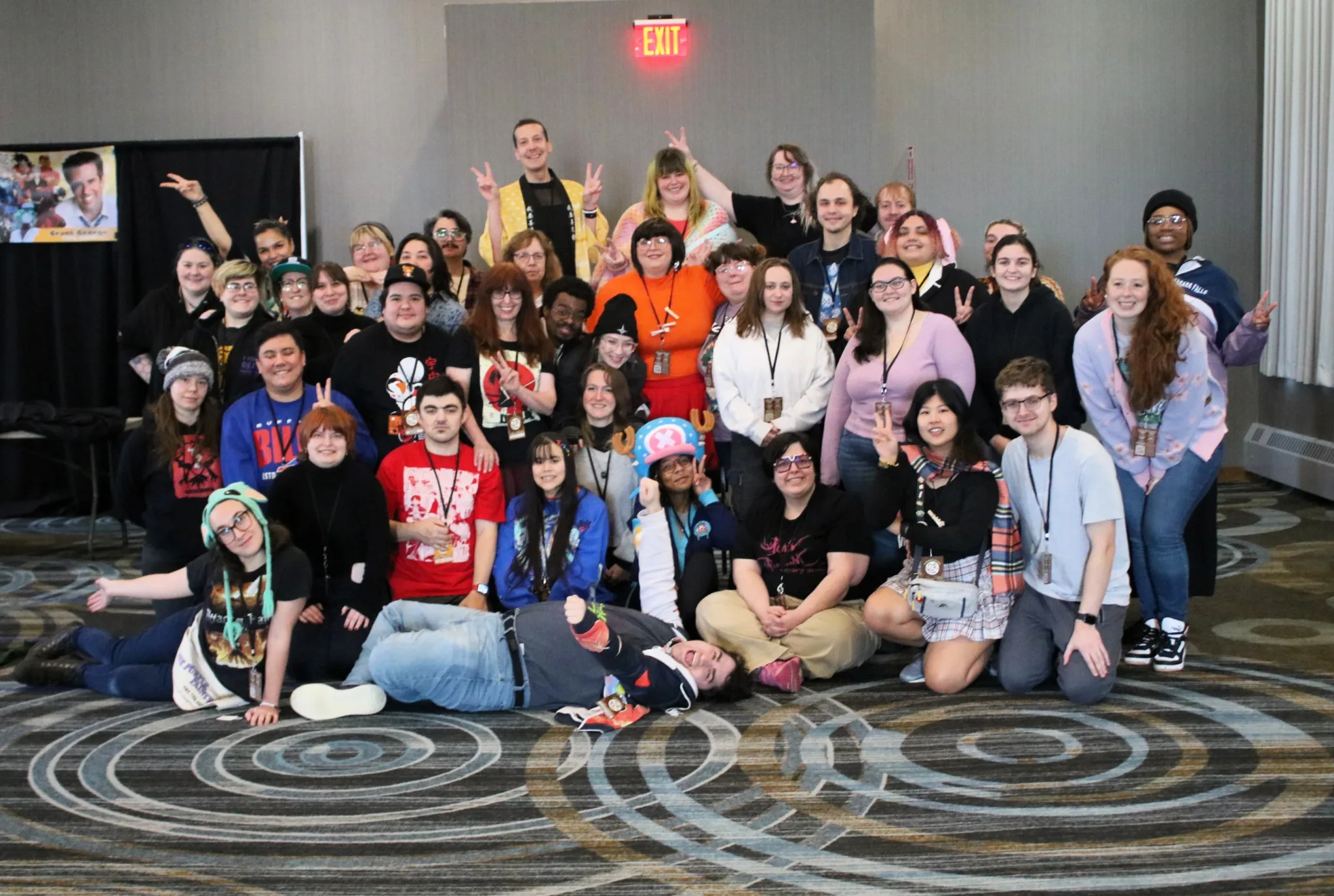 Group photo of all the artists and vendors at KinshokuCon 2025 standing together inside the DoubleTree event space.