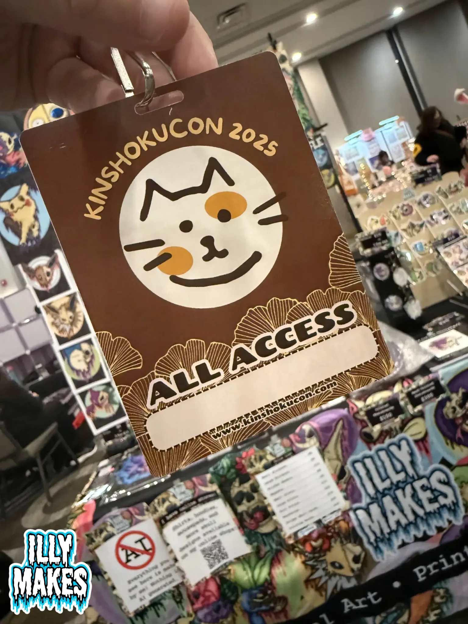 KinshokuCon 2025 artist badge with lanyard on a black background.