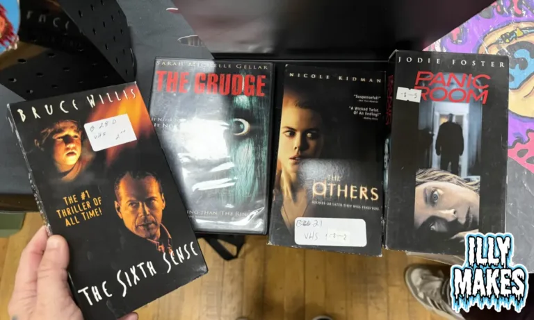 Stack of spooky movie finds including The Grudge on DVD, and The Others, Panic Room, and The Sixth Sense on VHS.